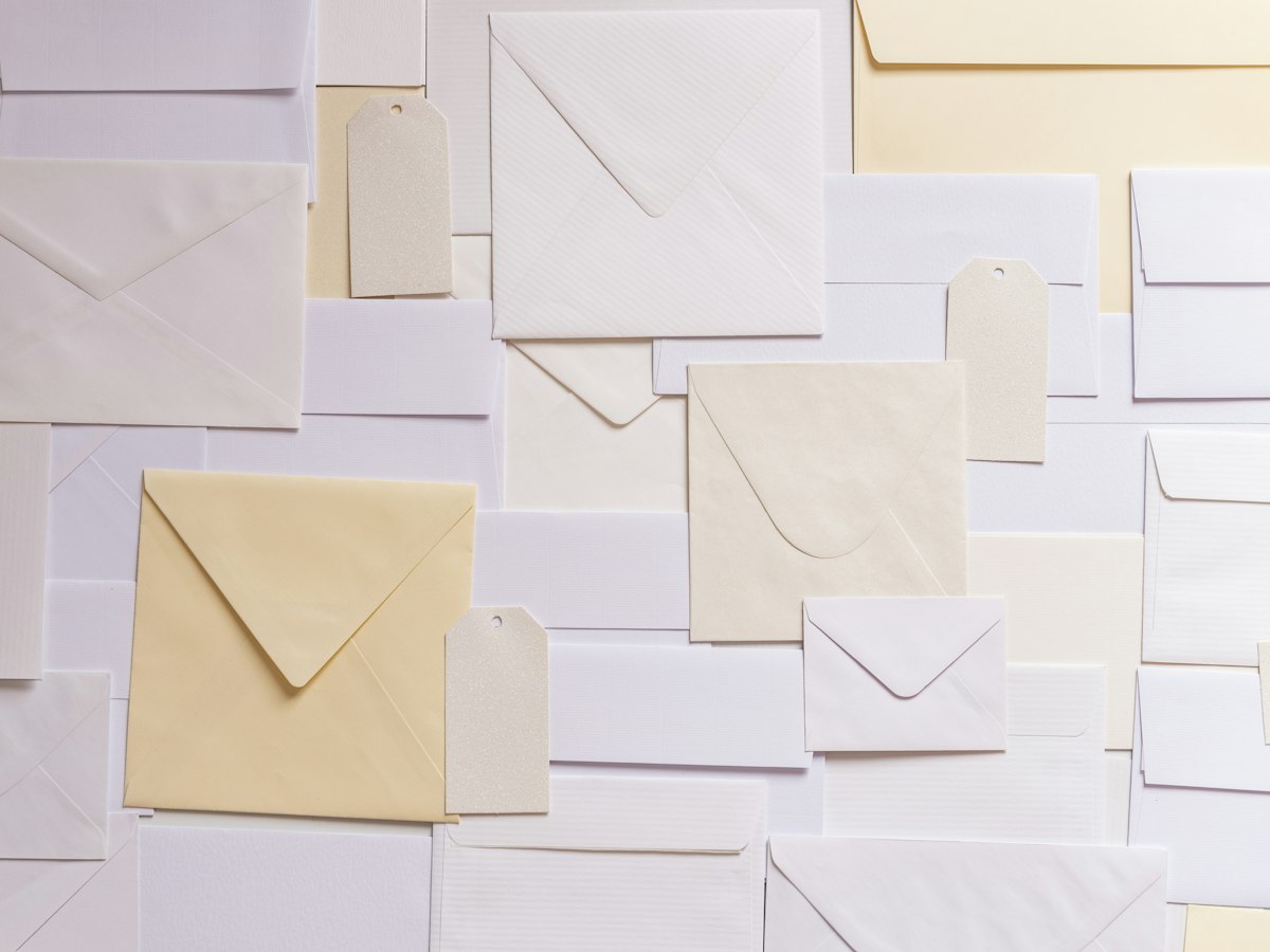Blush and lavender envelopes and cards arranged flat